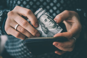 Woman putting money in a wallet