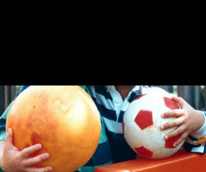 Child holding sports balls