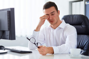 Man suffering from screen-related eye strain